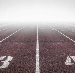 A foggy track field with visible lane numbers and white lines.